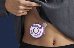 A patient wears the Enable Injections disc-shaped Enfuse device on their stomach. Medical device vc venture capital