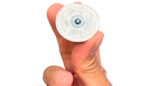 A photo of Biolinq’s glucose sensor held between two fingers.
