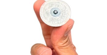 A photo of Biolinq’s glucose sensor held between two fingers.
